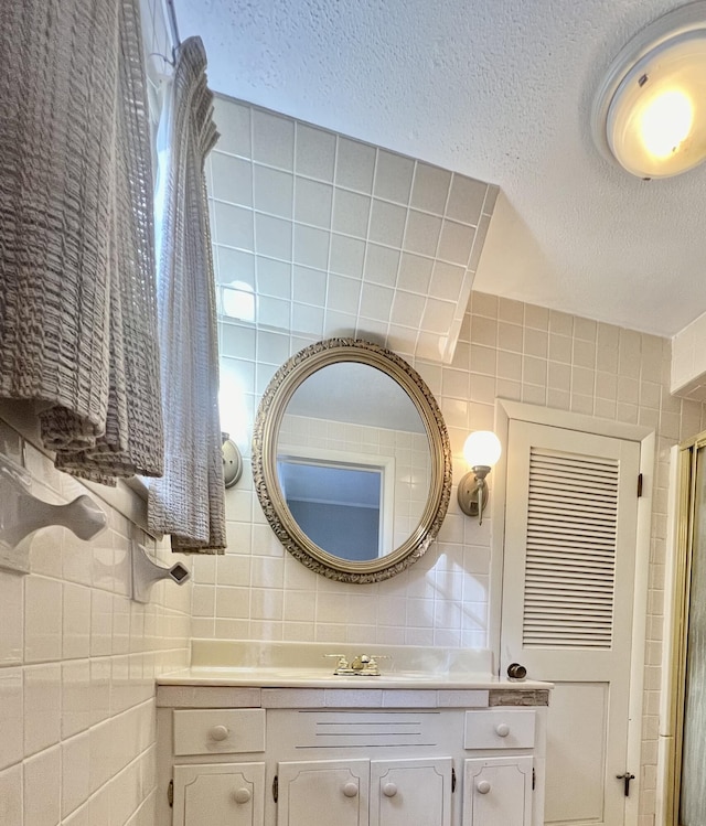 bathroom featuring tile walls, vanity, a textured ceiling, and tasteful backsplash