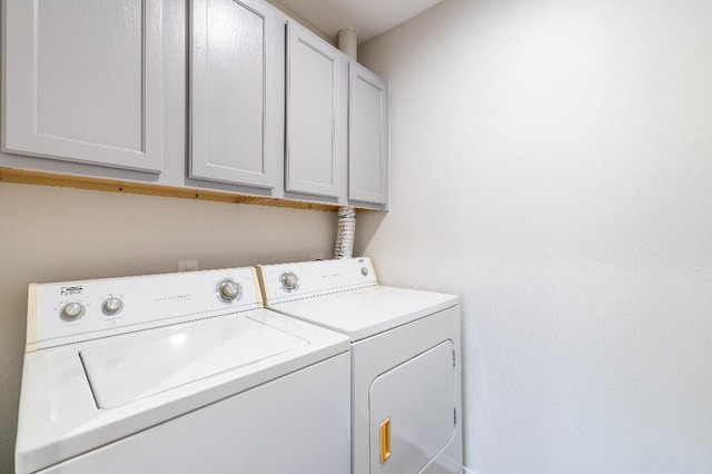 laundry area with cabinets and washing machine and clothes dryer