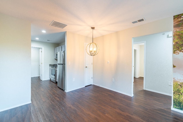 unfurnished room featuring a notable chandelier and dark hardwood / wood-style flooring