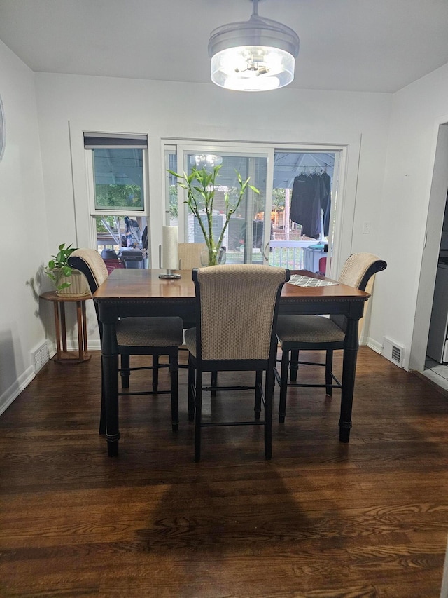 dining room with a notable chandelier and dark hardwood / wood-style flooring