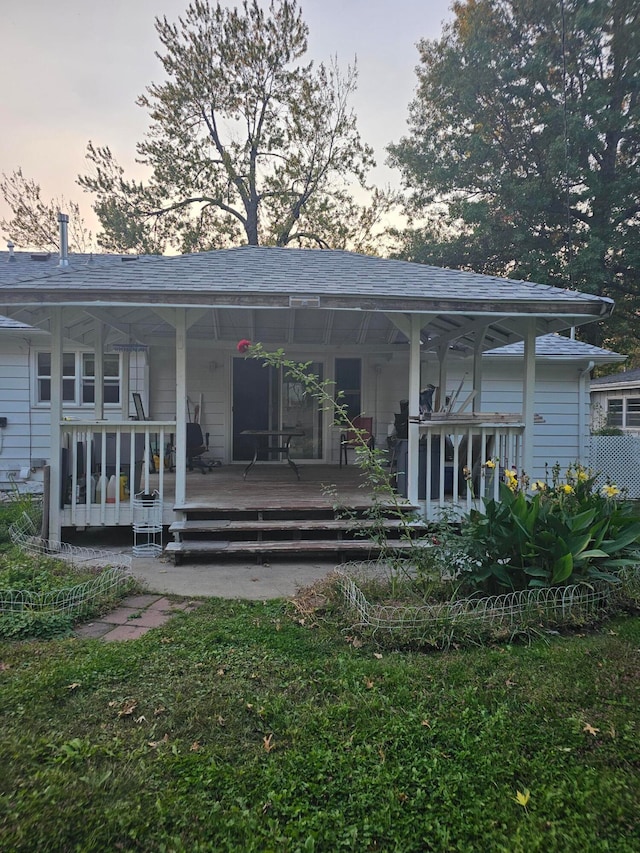 back house at dusk with a porch