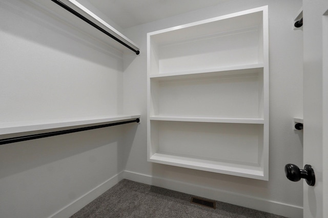 spacious closet featuring dark carpet