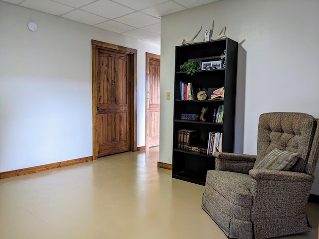 living area featuring a drop ceiling