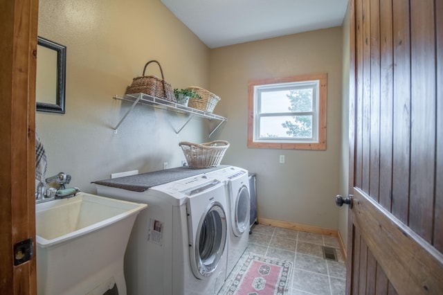 washroom featuring light tile patterned floors, sink, and washer and clothes dryer