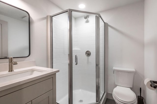 full bathroom with a stall shower, vanity, and toilet