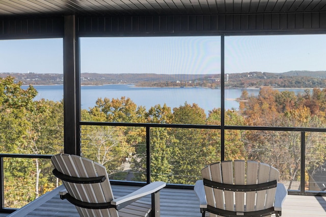 sunroom / solarium featuring a water view