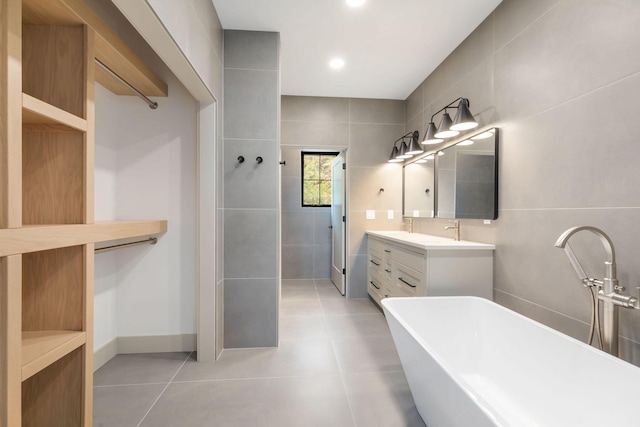 bathroom with double vanity, tile patterned flooring, a freestanding tub, walk in shower, and recessed lighting