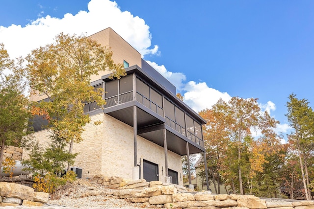 view of building exterior featuring an attached garage and central AC