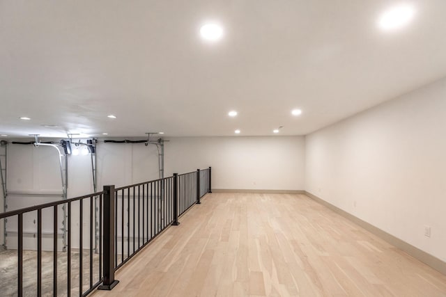 basement with baseboards, light wood finished floors, and recessed lighting