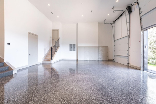 garage featuring baseboards, recessed lighting, and electric panel