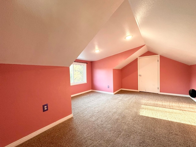 bonus room featuring carpet floors, a textured ceiling, and vaulted ceiling