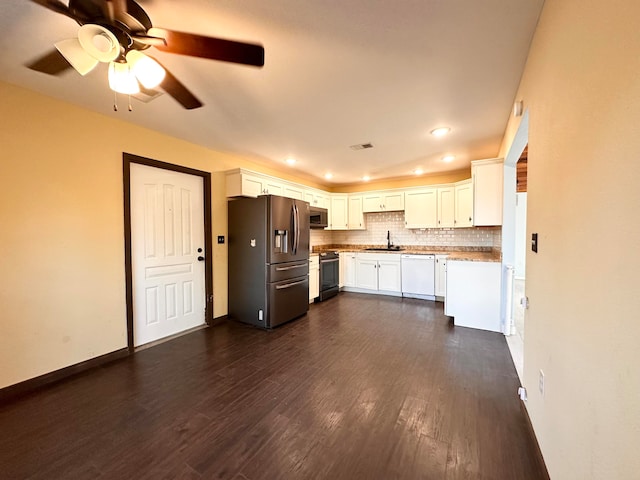 kitchen with tasteful backsplash, appliances with stainless steel finishes, sink, white cabinets, and dark hardwood / wood-style floors