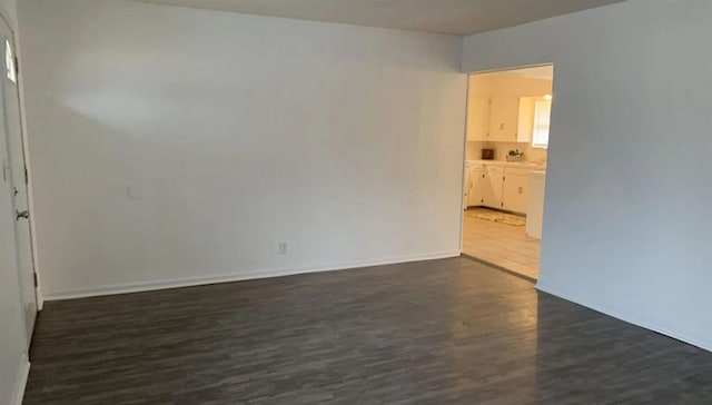 spare room with dark wood-type flooring