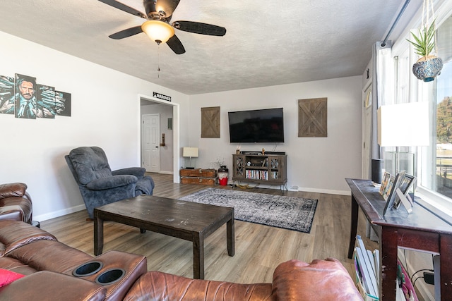 living room featuring a textured ceiling, hardwood / wood-style flooring, and ceiling fan