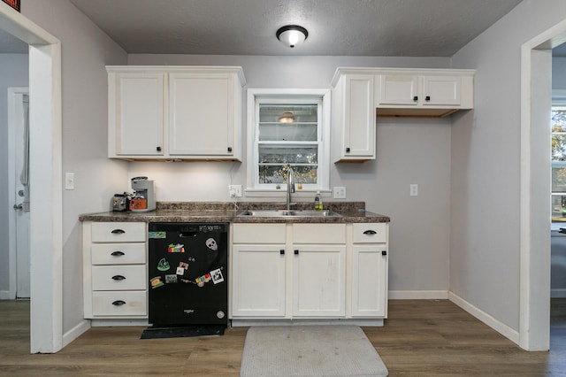 kitchen featuring dishwasher, dark wood-type flooring, sink, white cabinetry, and a textured ceiling