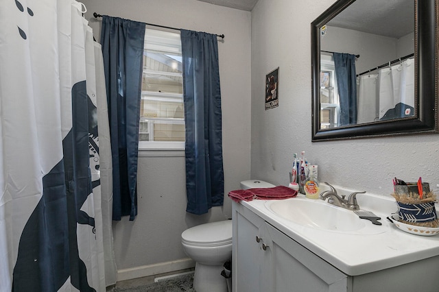 bathroom with vanity, a textured ceiling, toilet, and walk in shower