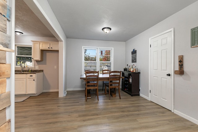 dining area with a textured ceiling, sink, and hardwood / wood-style floors