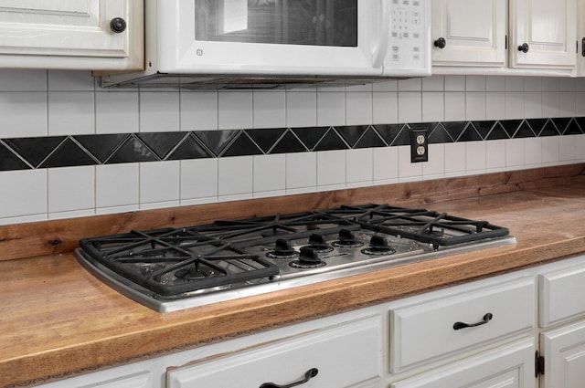 kitchen with stainless steel gas cooktop, white cabinets, and tasteful backsplash