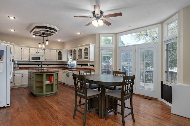 dining space featuring radiator heating unit, sink, dark hardwood / wood-style flooring, a textured ceiling, and ceiling fan