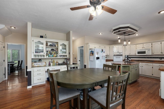 dining space with a textured ceiling, dark wood-type flooring, and ceiling fan