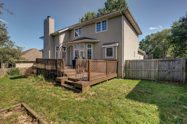 back of house with a wooden deck and a lawn