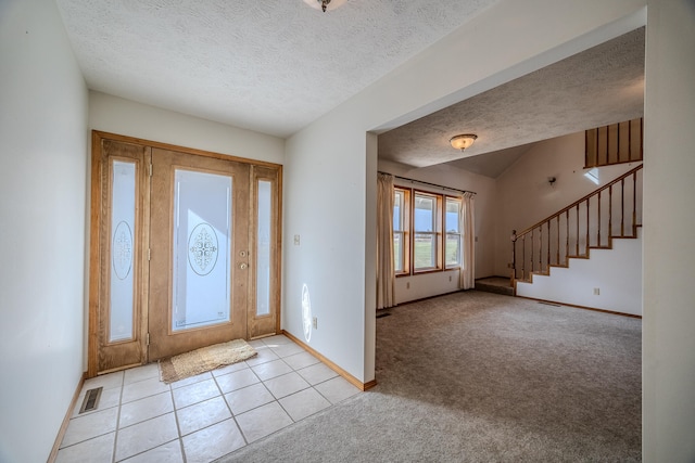 carpeted entrance foyer featuring a textured ceiling