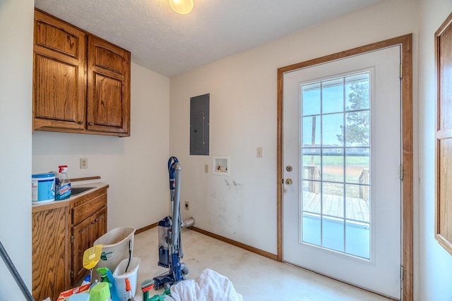 interior space with a textured ceiling, baseboards, light carpet, and electric panel