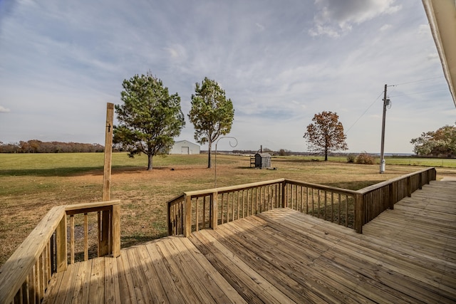 wooden deck with a rural view, a storage shed, and a lawn