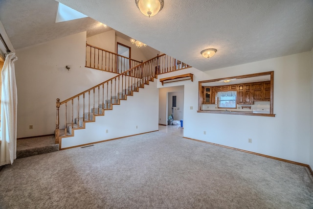 unfurnished living room featuring vaulted ceiling, light colored carpet, and a textured ceiling