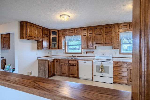 kitchen with white appliances, brown cabinets, and a sink