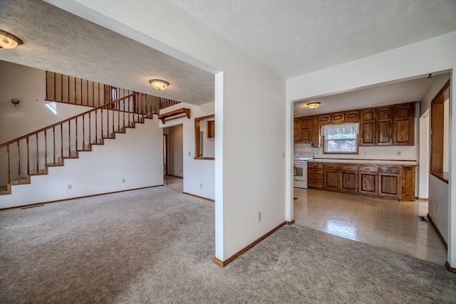 kitchen with light colored carpet, a textured ceiling, and white range with electric stovetop