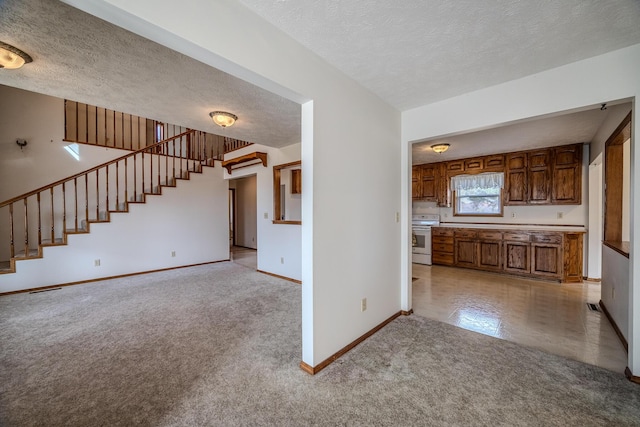 unfurnished living room featuring light carpet, a textured ceiling, stairs, baseboards, and visible vents