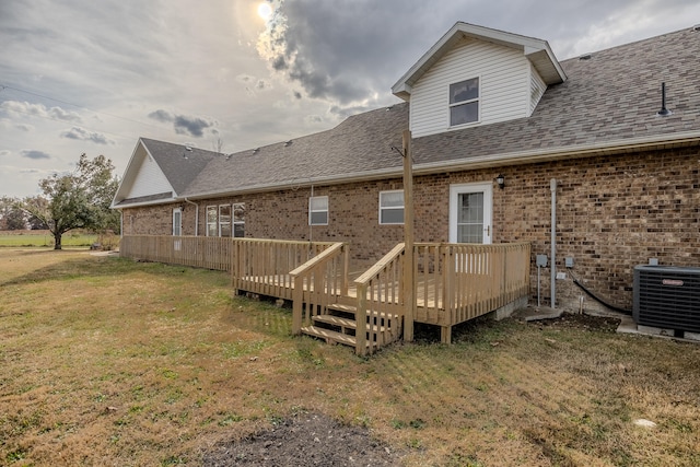 back of house with a wooden deck, a yard, and central AC