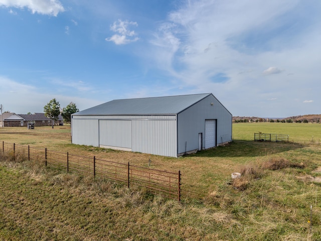 view of outdoor structure featuring a rural view and a yard