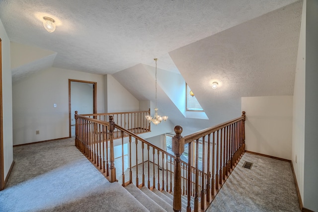 additional living space featuring lofted ceiling with skylight, carpet flooring, a textured ceiling, and a chandelier