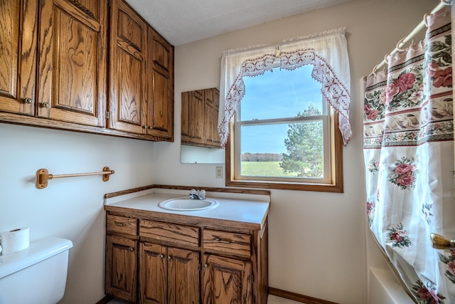 full bathroom with vanity, shower / tub combo, a textured ceiling, and toilet