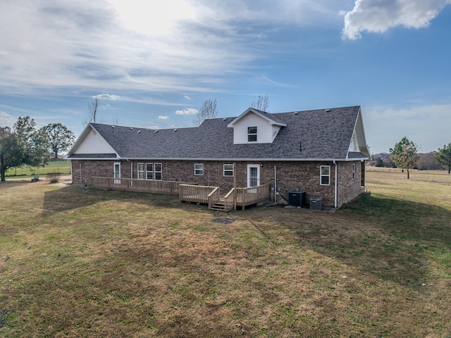 rear view of property with central AC unit, a lawn, and a deck