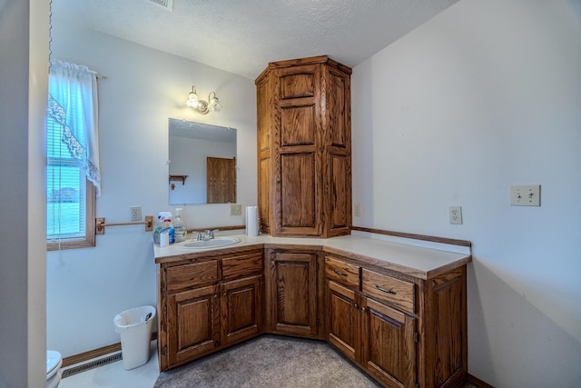 bathroom featuring vanity, a textured ceiling, visible vents, and toilet