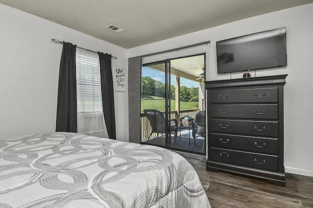 bedroom featuring a textured ceiling, dark hardwood / wood-style floors, and access to exterior