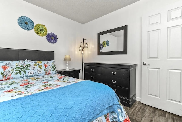 bedroom featuring a textured ceiling and dark hardwood / wood-style floors