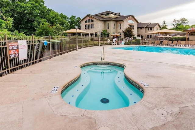 view of pool with a hot tub and a patio