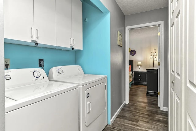 clothes washing area with dark wood-type flooring, independent washer and dryer, a textured ceiling, and cabinets