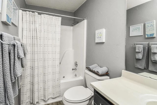 full bathroom featuring vanity, shower / bath combination with curtain, a textured ceiling, and toilet