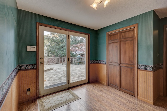 entryway with a textured ceiling and light wood-type flooring