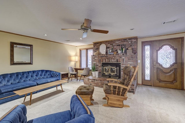 living room featuring ceiling fan, light carpet, a wood stove, and ornamental molding