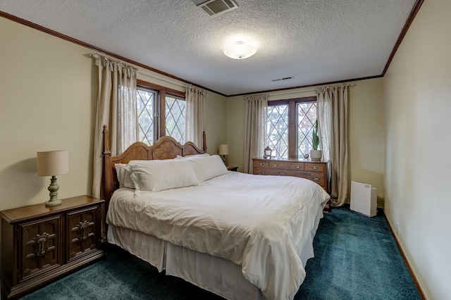 bedroom with a textured ceiling, multiple windows, and dark carpet