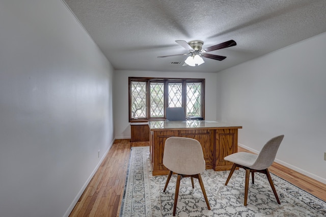 office featuring light hardwood / wood-style floors, a textured ceiling, and ceiling fan