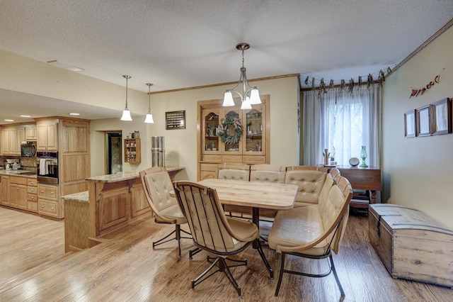 dining room with crown molding, a textured ceiling, light hardwood / wood-style flooring, and a chandelier