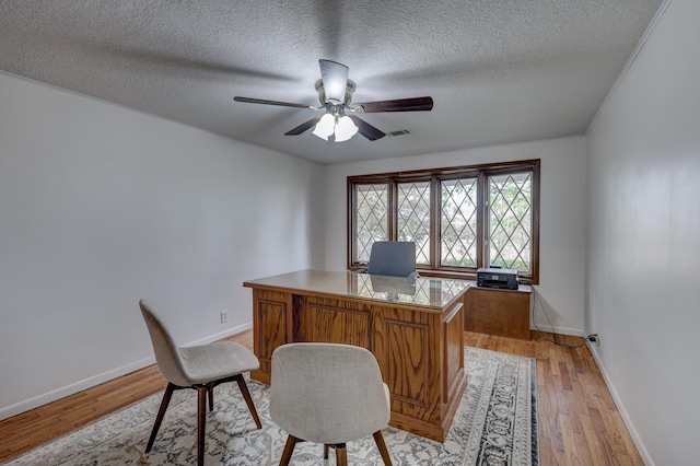 office featuring light hardwood / wood-style floors, a textured ceiling, and ceiling fan