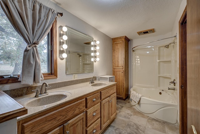 bathroom with vanity, shower / tub combination, and a textured ceiling